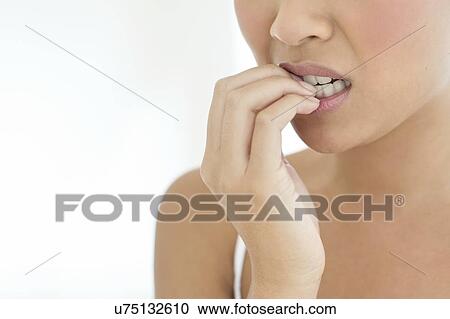 Stock Image - Woman biting nails. Fotosearch