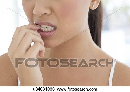Stock Image - Woman biting nails. Fotosearch