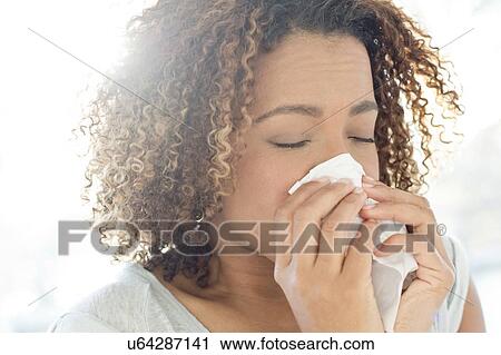Woman blowing nose on tissue View Large Photo Image Stock Image - Woman blowing nose on tissue. Fotosearch