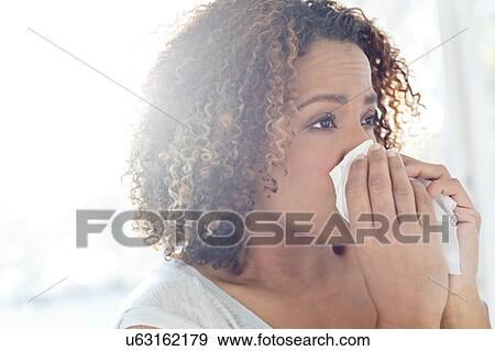 Woman blowing nose on tissue View Large Photo Image Stock Photo - Woman blowing nose on tissue. Fotosearch