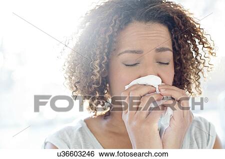 Stock Photograph - Woman blowing nose on tissue. Fotosearch