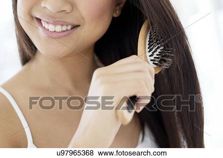 Woman brushing hair View Large Photo Image Stock Photo - Woman brushing hair. Fotosearch