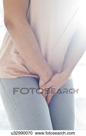 Stock Image - Woman clutching stomach in pain. Fotosearch