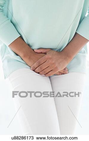 Stock Image - Woman clutching stomach in pain. Fotosearch