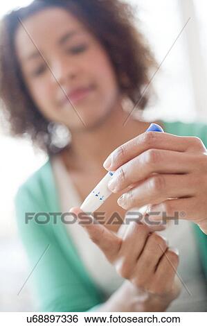 Woman doing finger prick test View Large Photo Image Stock Photograph - Woman doing finger prick test. Fotosearch