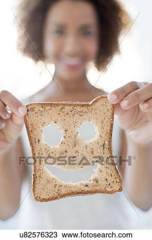 Woman holding bread with smiley face View Large Photo Image Stock Image - Woman holding bread with smiley face. Fotosearch