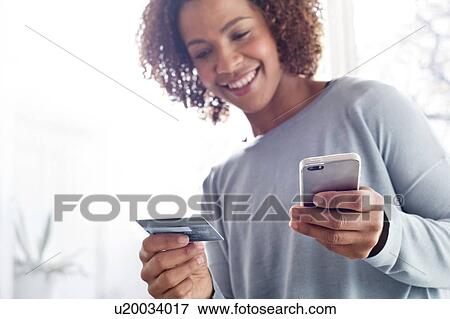 Woman holding credit card and phone View Large Photo Image Stock Photo - Woman holding credit card and phone. Fotosearch
