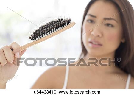 Woman holding hairbrush with worried expression View Large Photo Image Stock Image - Woman holding hairbrush with worried expression. Fotosearch