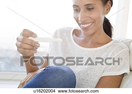 Picture - Woman holding pregnancy test. Fotosearch