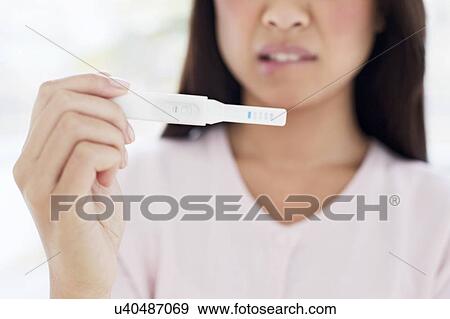 Stock Photo - Woman holding pregnancy test. Fotosearch