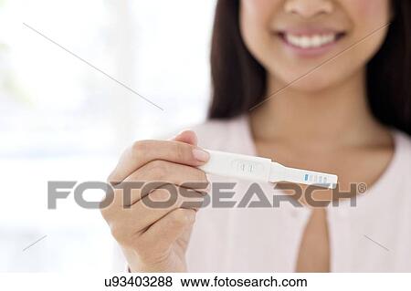 Stock Photo - Woman holding pregnancy test. Fotosearch