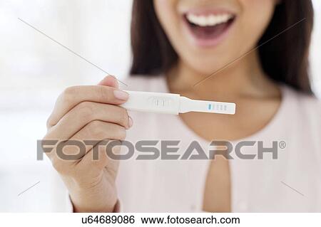 Stock Photograph - Woman holding pregnancy test. Fotosearch