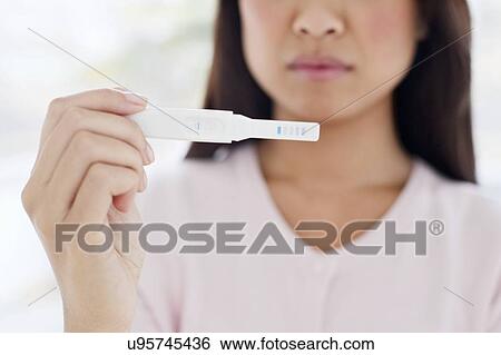 Woman holding pregnancy test View Large Photo Image Stock Photograph - Woman holding pregnancy test. Fotosearch