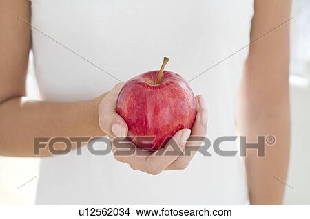 Picture - Woman holding red apple. Fotosearch