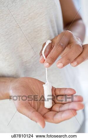 Picture - Woman holding tampon. Fotosearch