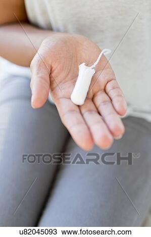 Stock Image - Woman holding tampon. Fotosearch