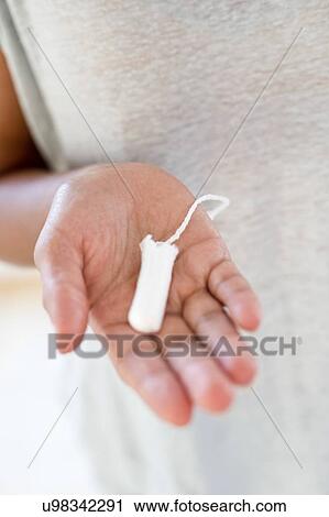 Stock Image - Woman holding tampon. Fotosearch