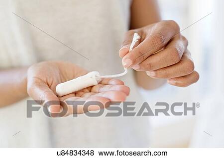 Stock Photo - Woman holding tampon. Fotosearch