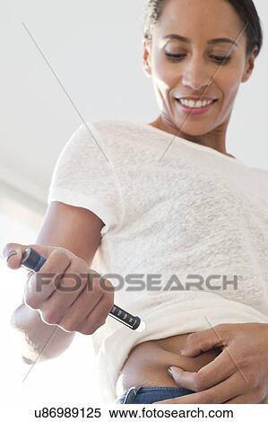 Woman injecting herself in tummy View Large Photo Image Stock Photography - Woman injecting herself in tummy. Fotosearch