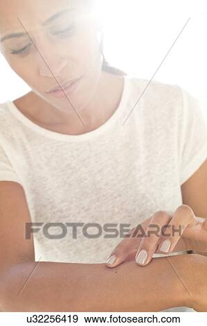 Woman inspecting mole on arm View Large Photo Image Stock Photo - Woman inspecting mole on arm. Fotosearch