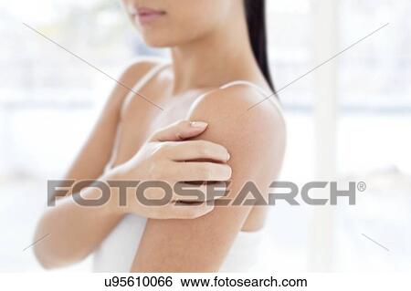 Stock Photograph - Woman scratching shoulder. Fotosearch