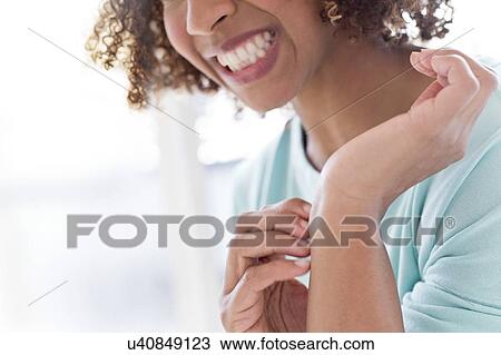 Stock Image - Woman scratching wrist. Fotosearch