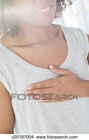 Woman touching chest View Large Photo Image Picture - Woman touching chest. Fotosearch