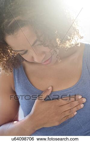 Woman touching chest View Large Photo Image Stock Photograph - Woman touching chest. Fotosearch
