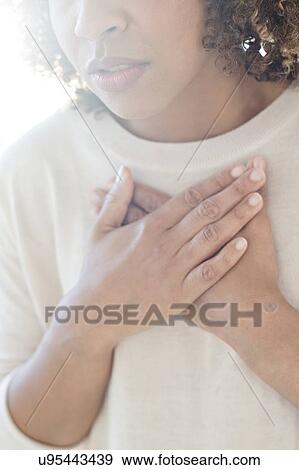 Woman touching her chest View Large Photo Image Stock Photo - Woman touching her chest. Fotosearch