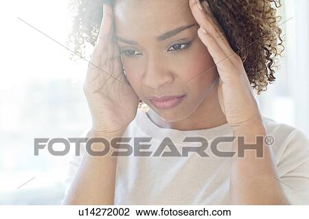 Stock Image - Woman touching her head. Fotosearch