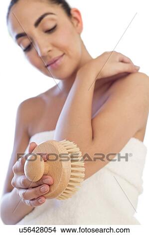 Picture - Woman using body brush on elbow. Fotosearch