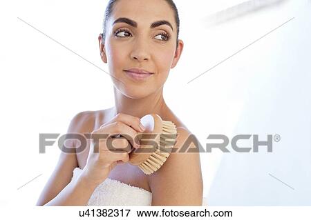 Stock Photo - Woman using body brush on shoulder. Fotosearch