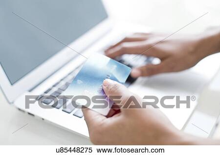 Stock Photography - Woman using credit card and laptop. Fotosearch