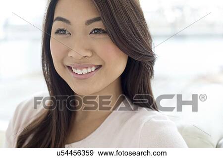Stock Photo - Woman with brown hair smiling and looking away. Fotosearch