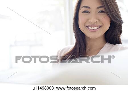 Stock Image - Woman with brown hair smiling towards camera. Fotosearch