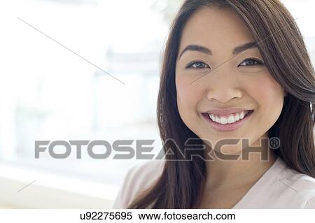 Stock Photography - Woman with brown hair smiling towards camera. Fotosearch