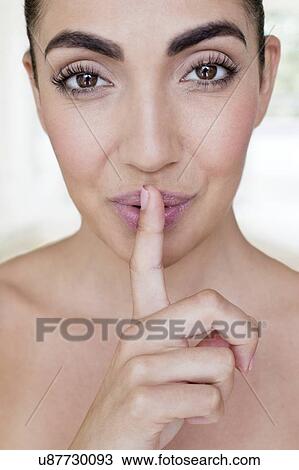 Stock Image - Woman with finger on lips. Fotosearch