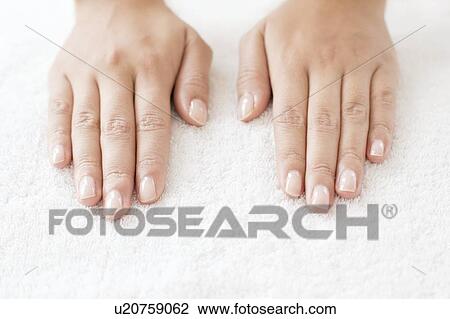 Stock Image - Woman with hands side by side on white towel. Fotosearch