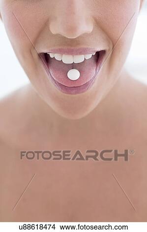 Picture - Woman with pill on tongue. Fotosearch