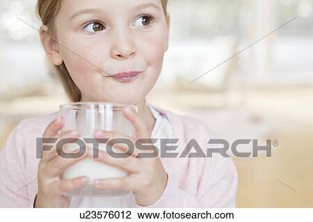 Stock Image - Young girl drinking glass of milk. Fotosearch