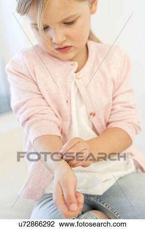 Stock Image - Young girl scratching arm. Fotosearch
