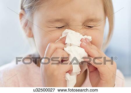 Stock Photo - Young girl sneezing into tissue. Fotosearch