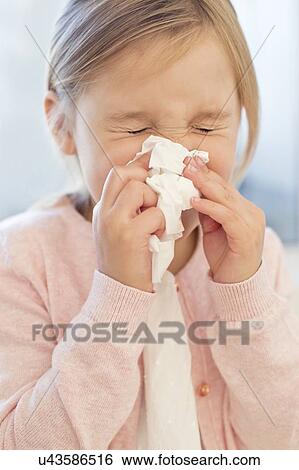 Young girl sneezing into tissue View Large Photo Image Stock Photograph - Young girl sneezing into tissue. Fotosearch