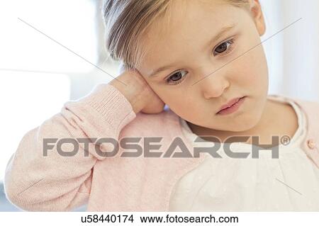 Picture - Young girl with ear ache. Fotosearch