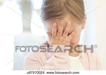 Picture - Young girl with hand on face. Fotosearch