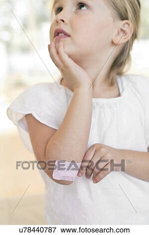 Stock Photo - Young girl with plaster on elbow. Fotosearch