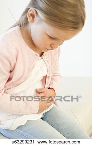 Stock Image - Young girl with tummy ache. Fotosearch