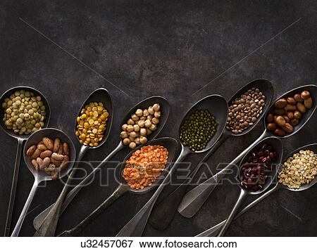 Stock Photo - Pulses on metal spoons. Fotosearch