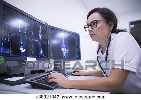 Radiologist studying scans View Large Photo Image Stock Photo - Radiologist studying scans. Fotosearch
