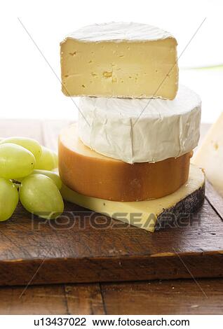 Stock Image - Assorted cheeses with grapes. Fotosearch